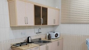 A compact kitchen with light-colored cabinets, a sink, and a toaster.