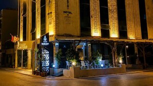 Un hotel con una fachada imponente, amplias columnas y un cartel que indica que es el Grand Marnier Hotel.