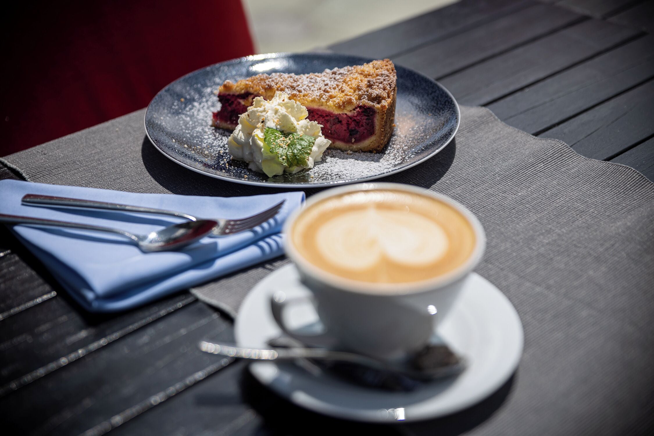 En tallerken med dessert, en kop kaffe og en ske.