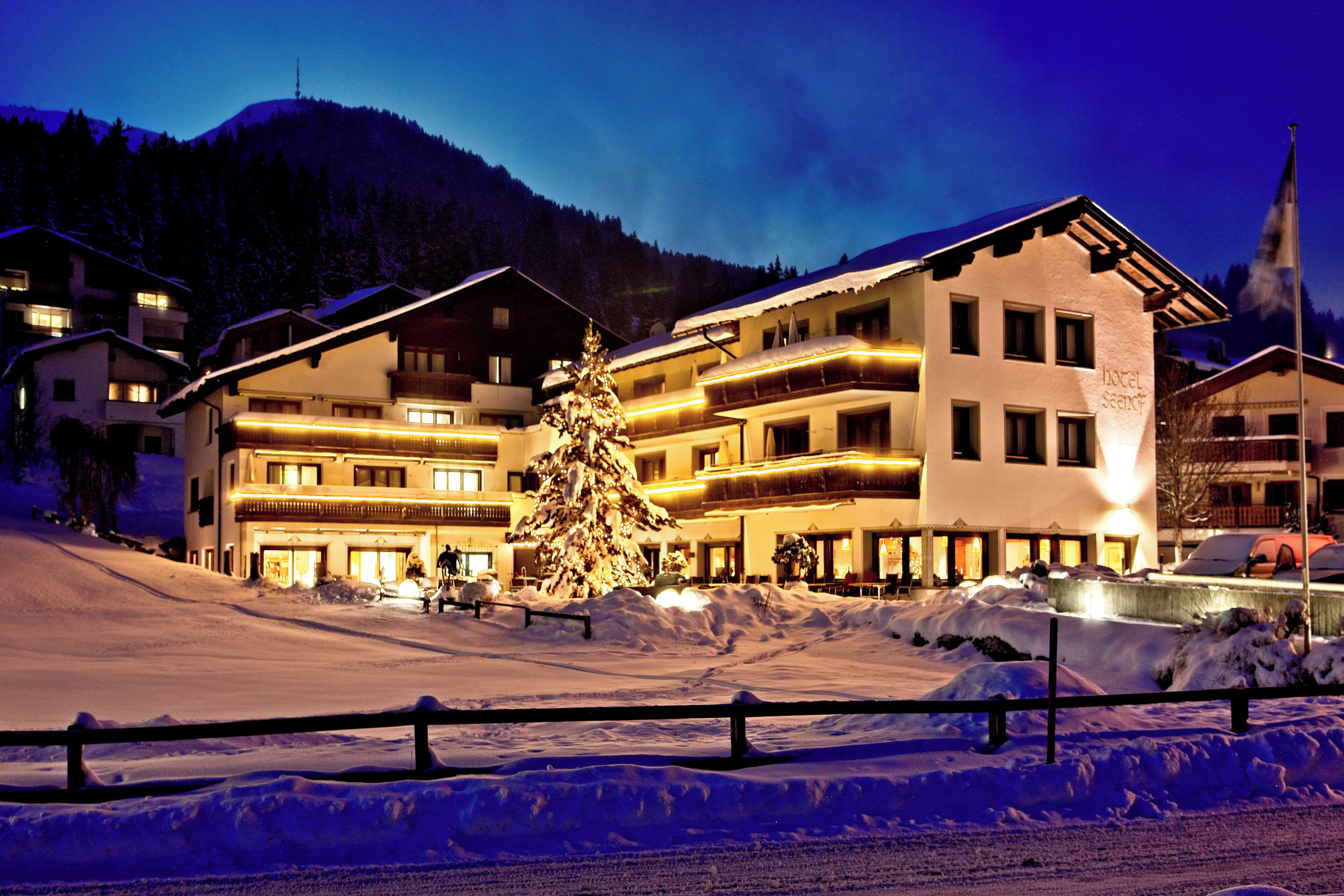 A hotel with multiple floors, balconies, and a snow-covered landscape.