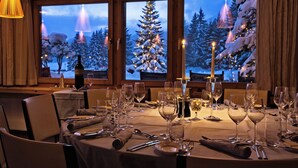 A dining area with a table set for a meal, a bottle, and candles.