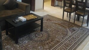 Un salon comprenant un canapé, une table basse, un téléviseur et un coin repas avec des chaises.