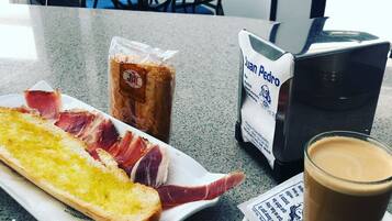 A meal with bread, ham, and a drink on a table in a cafe.