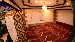 Una habitación con alfombra, un soporte para micrófono y carteles informativos en las paredes.