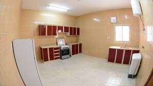 Una cocina con refrigerador, estufa y armarios.