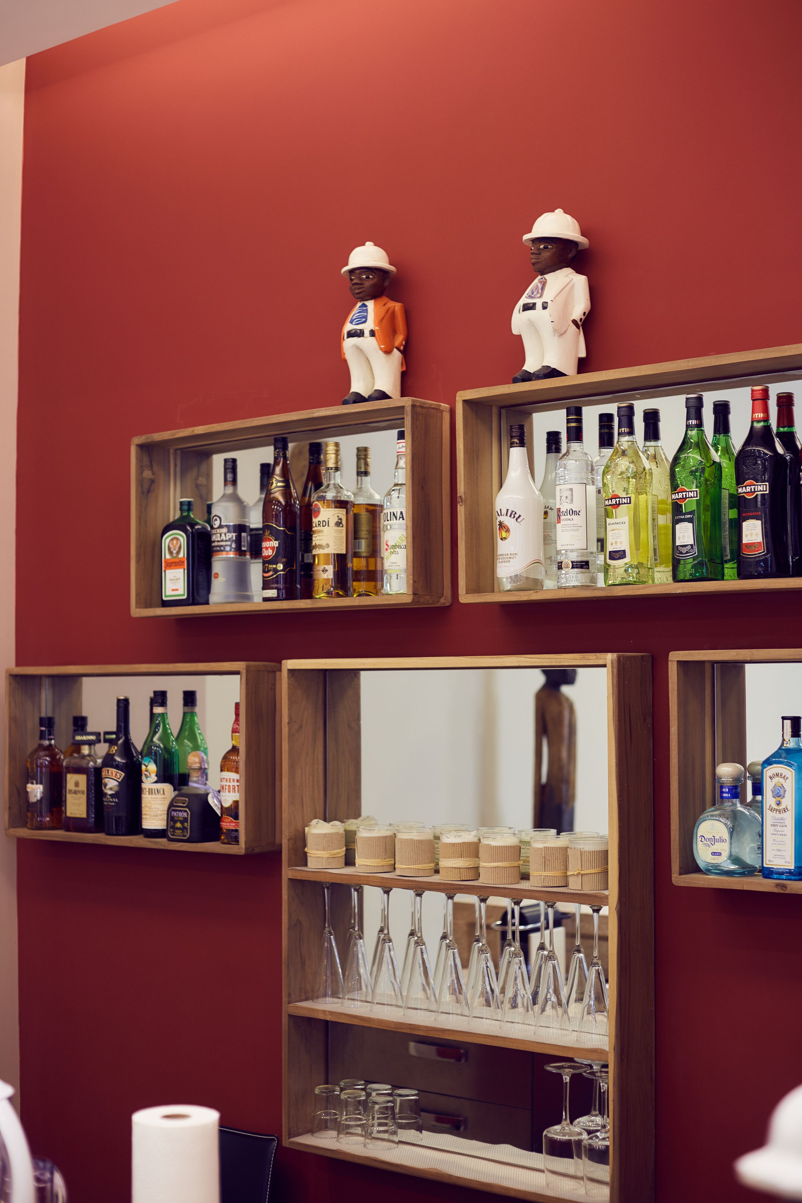 A bar area with shelves of liquor bottles and glasses.
