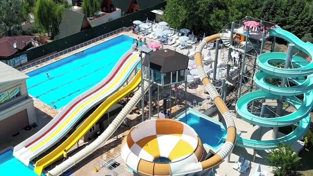 Ein Wasserpark mit mehreren Wasserrutschen und Pools, umgeben von Wohngebäuden.