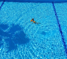 Una piscina techada, una piscina al aire libre de temporada, sombrillas