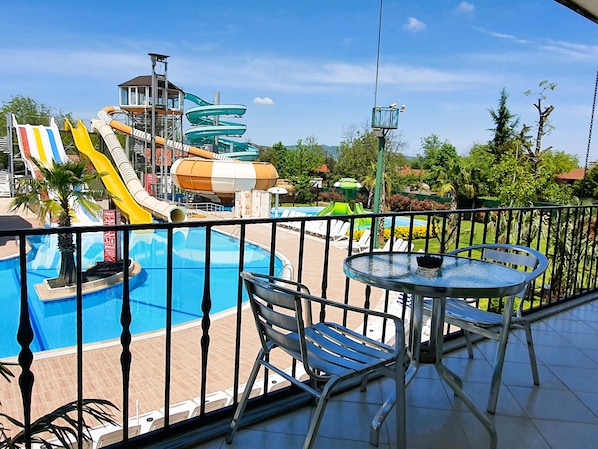 A pool area with a water slide, lounge chairs, and a table. - Sapanca Aqua Wellness Spa Hotel (Sapanca)