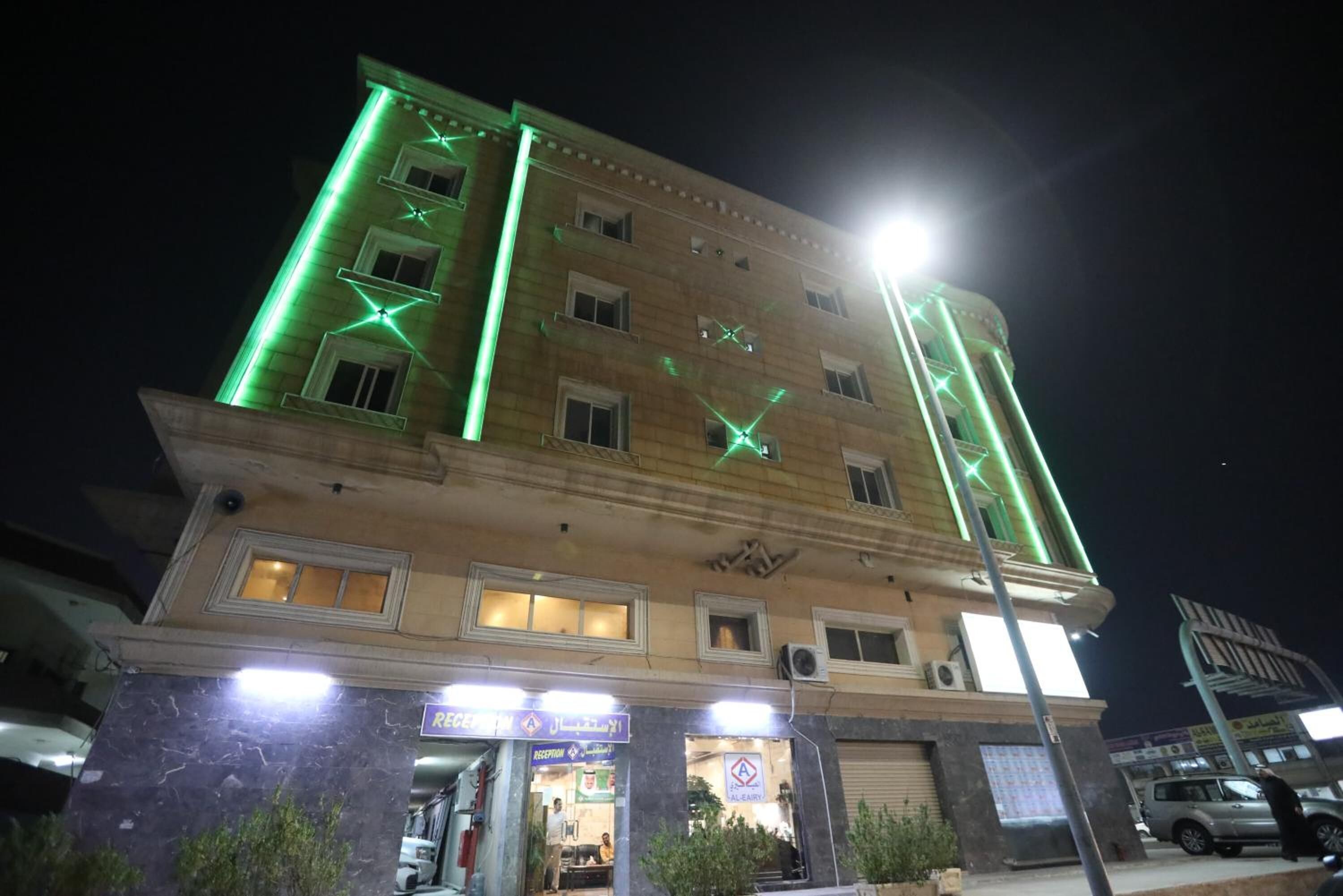 A multi-story building with a reception area at the ground level, featuring a sign with Arabic script.