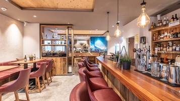 Un espace bar avec des meubles en bois, un comptoir et une tireuse à bière.