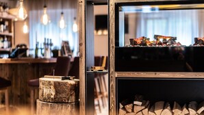 Een bar met houten planken, een rustieke houten kruk en een stapel haardhout.