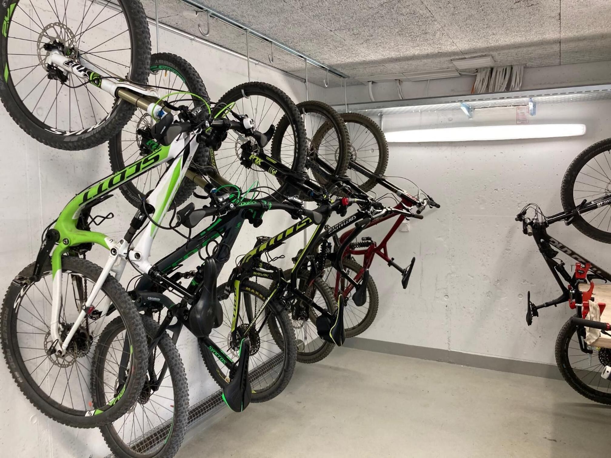 A parking garage with bicycles mounted on a wall.