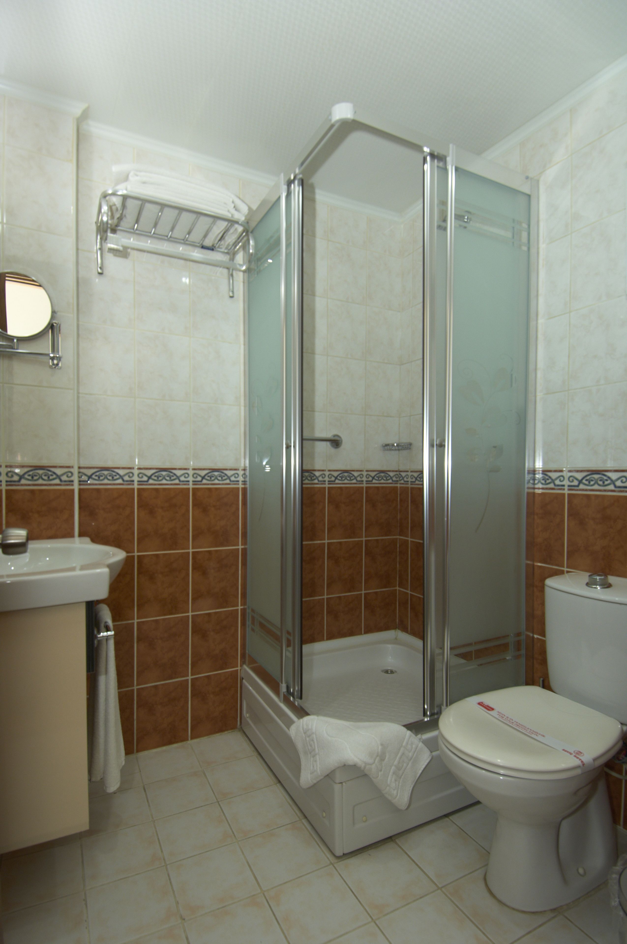 Un bany amb dutxa de vidre, un lavabo i un vàter.