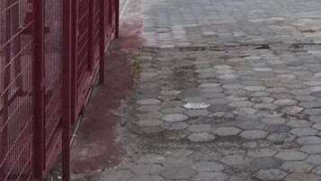 Ett asfalterat område med en vit bil parkerad i närheten.