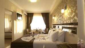 A hotel room with a large bed, a desk, a chair, and a view of the outdoors. - Soyic Hotel (Eskisehir)