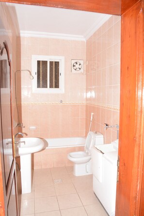 A bathroom with a sink, toilet, and bathtub.