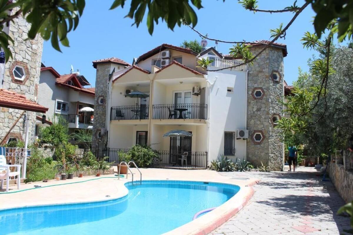 Un edificio de varios pisos con piscina, balcones y fachada de piedra.