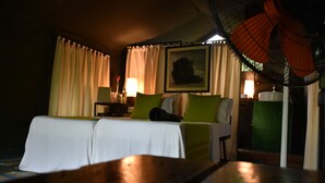 Una habitación de hotel con cama, una silla, una mesa, una lámpara y un cuadro en la pared.
