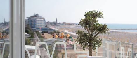 A balcony with a view of a beach and cityscape.
