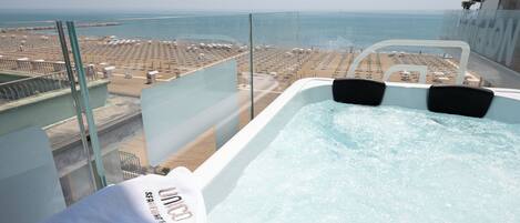 Un jacuzzi con vista a la playa y al paisaje urbano.