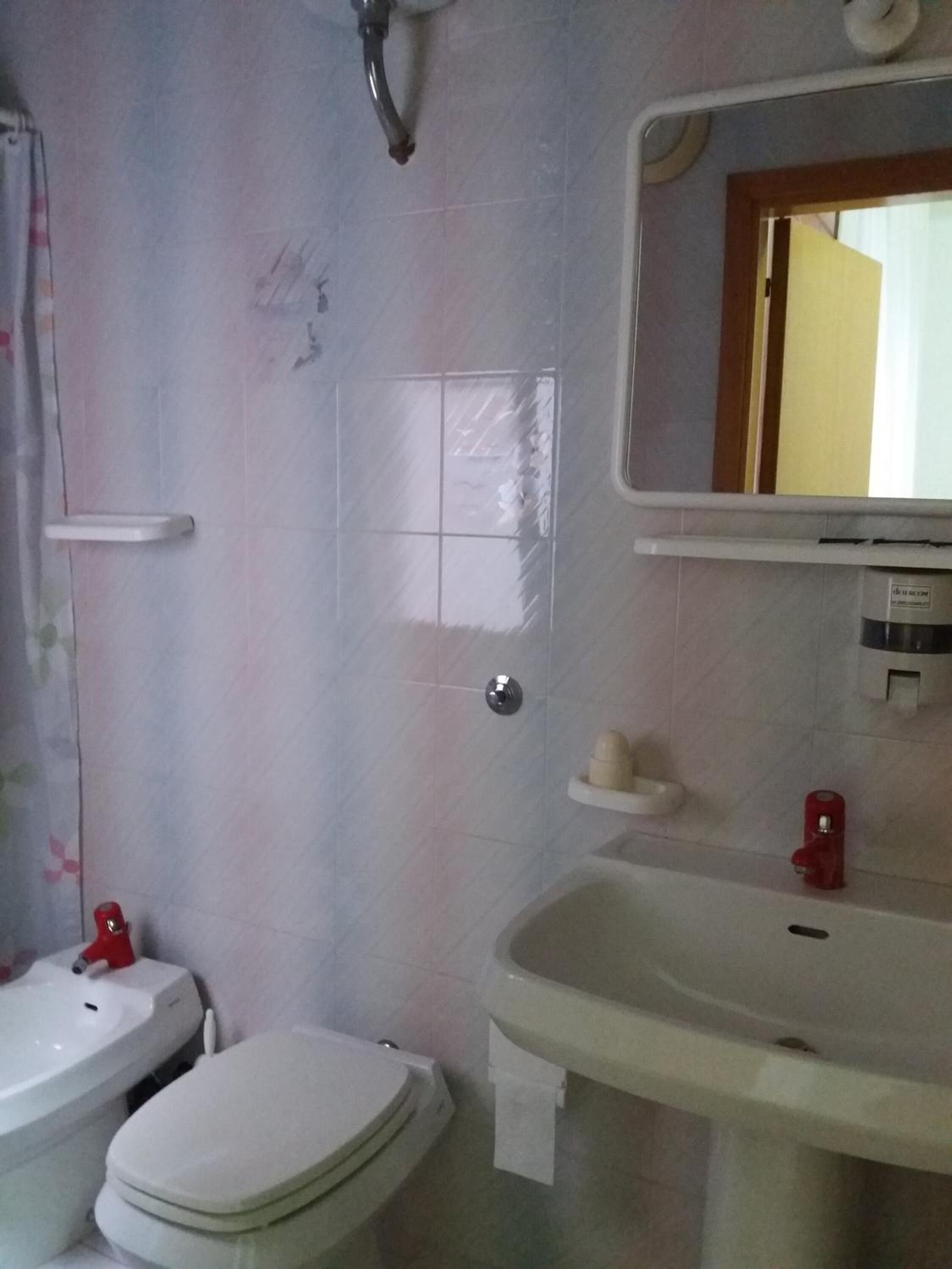 Un baño con inodoro, lavabo y espejo.