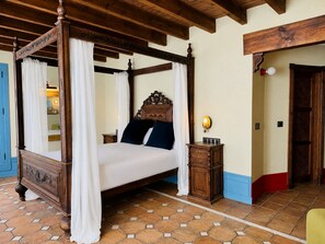 A four-poster bed with a canopy, a bedside table with a lamp, and a tiled floor. - Hotel Boutique Palacete del Corregidor (Almunecar)