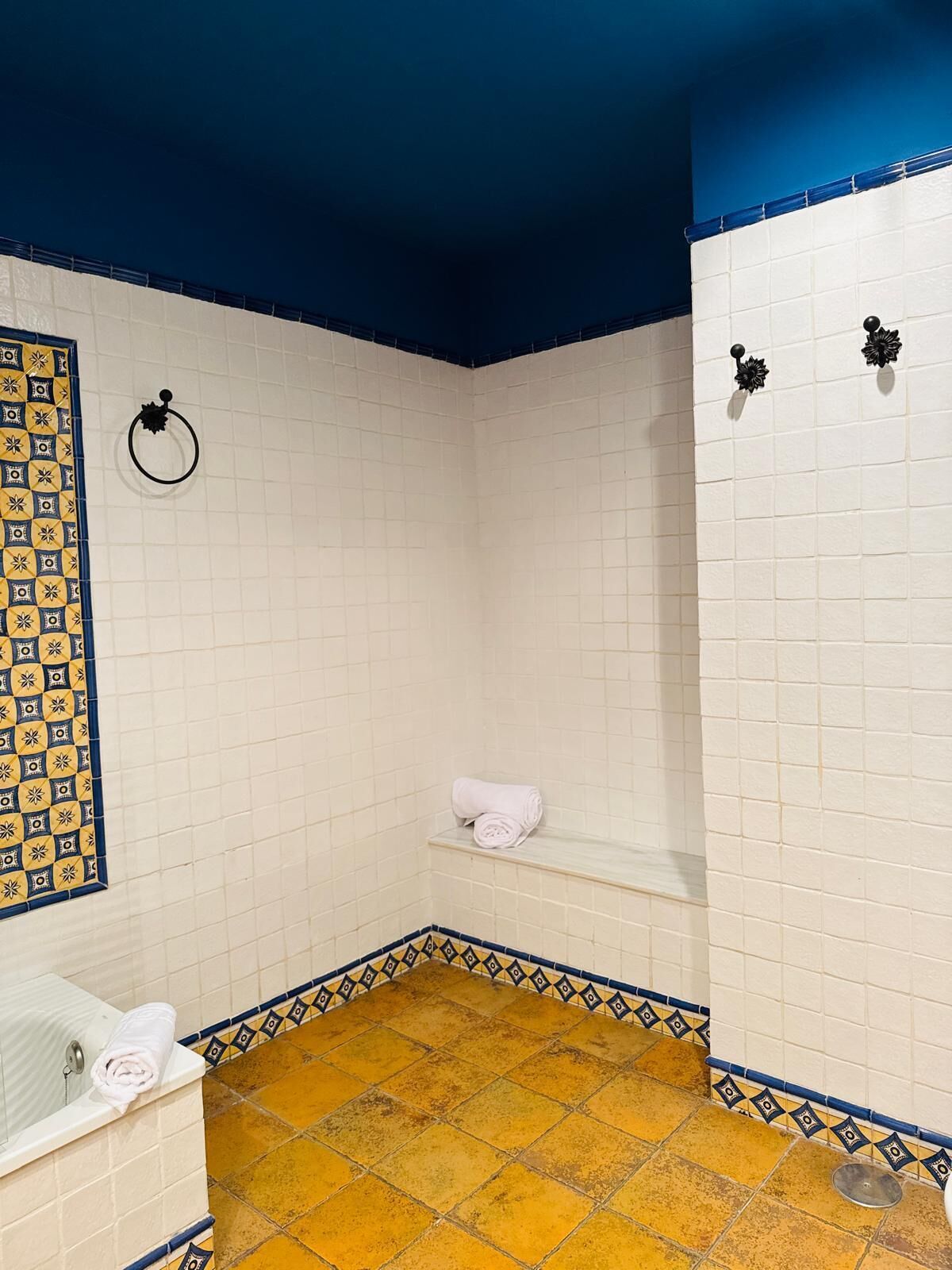 A bathroom with a bathtub, a towel rack, and a shelf with a towel.