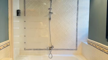 Ein Badezimmer mit Badewanne, Toilette und einem Holzkosmetikschrank mit Handtüchern.