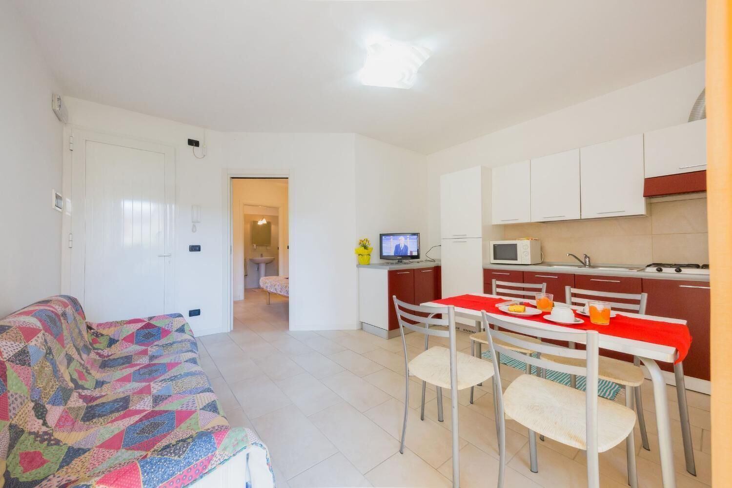 Un espacio habitable compacto con kitchenette, comedor y habitación.