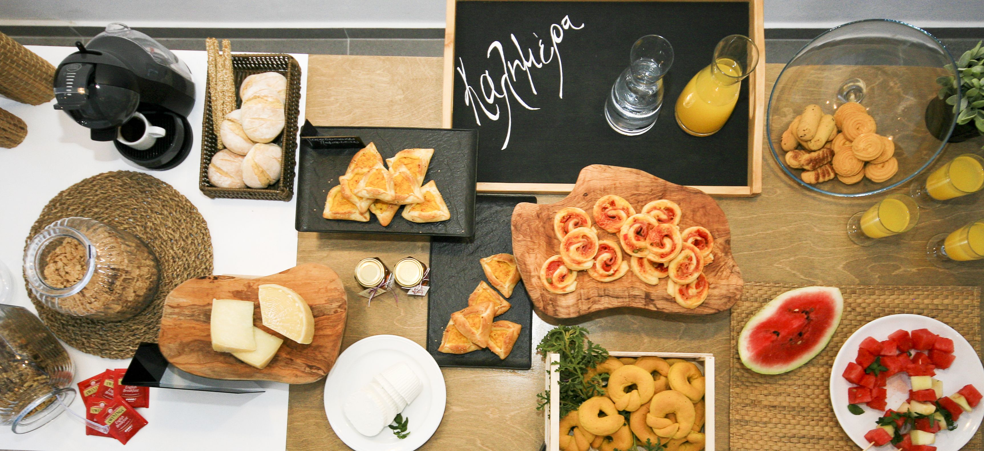 A breakfast buffet with various food items, including pastries, cheese, and fruit.