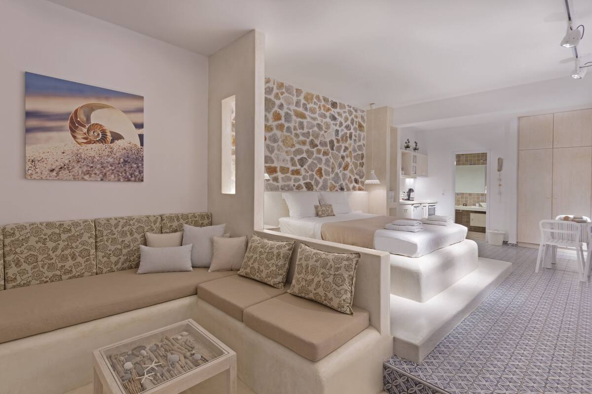 Een moderne woonkamer met een beige bank, een bijzettafeltje en een schilderij van een schelp.