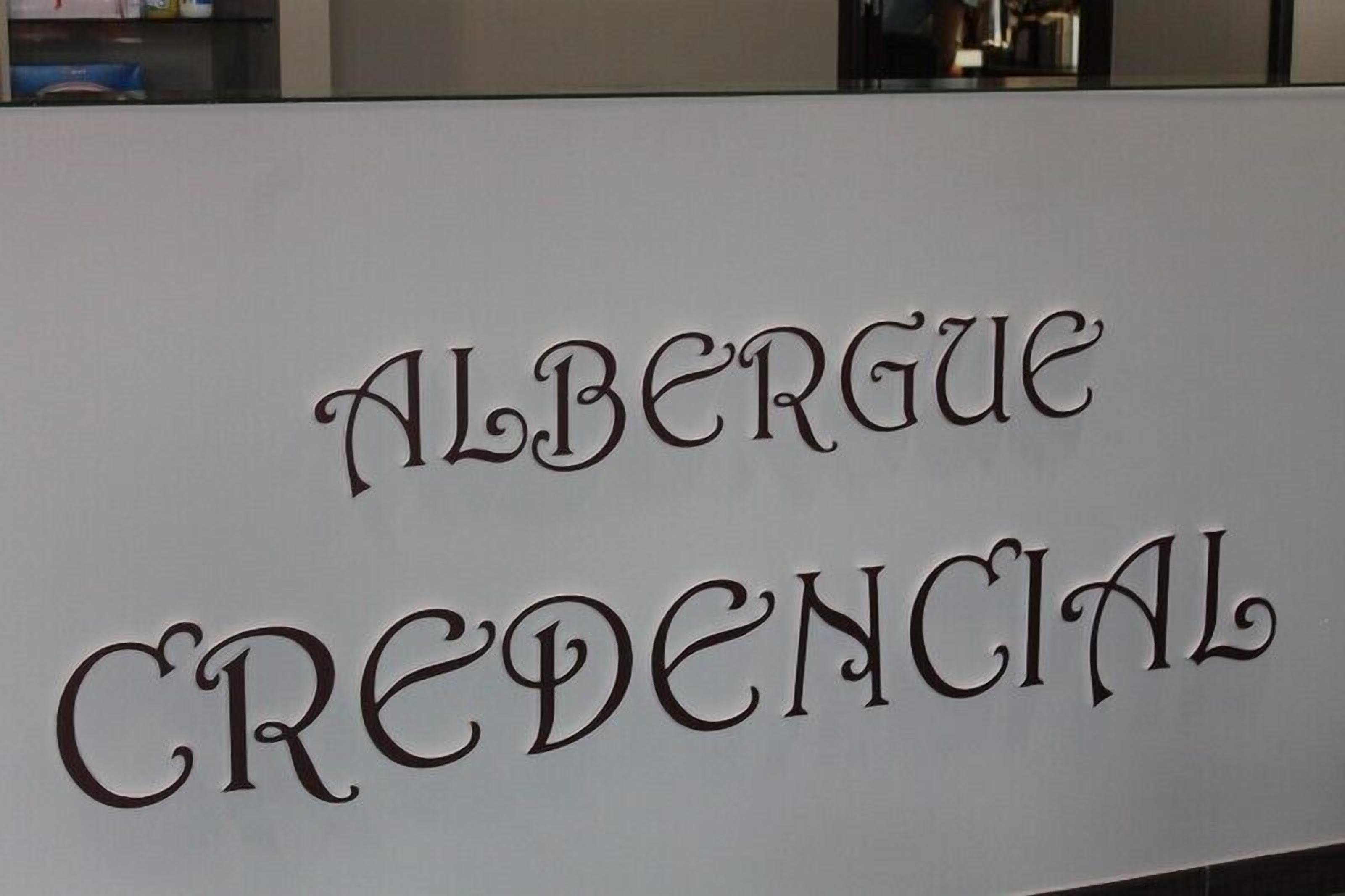 A sign with the text "ALBÉRGUE CREDENCIAL".
