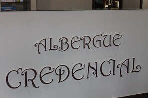 A sign with the text "ALBÉRGUE CREDENCIAL".