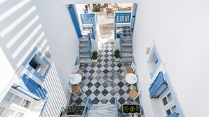 A narrow courtyard with checkered flooring, blue doors, and white walls. - Fanouris Condo by Meraki Collection Adults Only (18+) accommodation (Santorini)