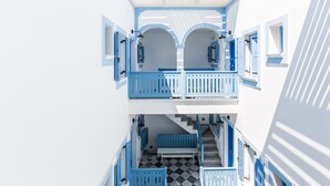 A multi-level building with blue railings and white walls, featuring a staircase and a bench. - Fanouris Condo by Meraki Collection Adults Only (18+) accommodation (Santorini)