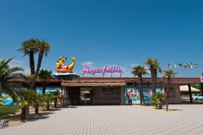 A beachside building with a large sign reading "Aquafollie" and a mascot figure. - Villette (Caorle)