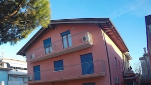 Un immeuble à deux étages doté de balcons, d’une entrée sécurisée et surplombant un ciel dégagé.