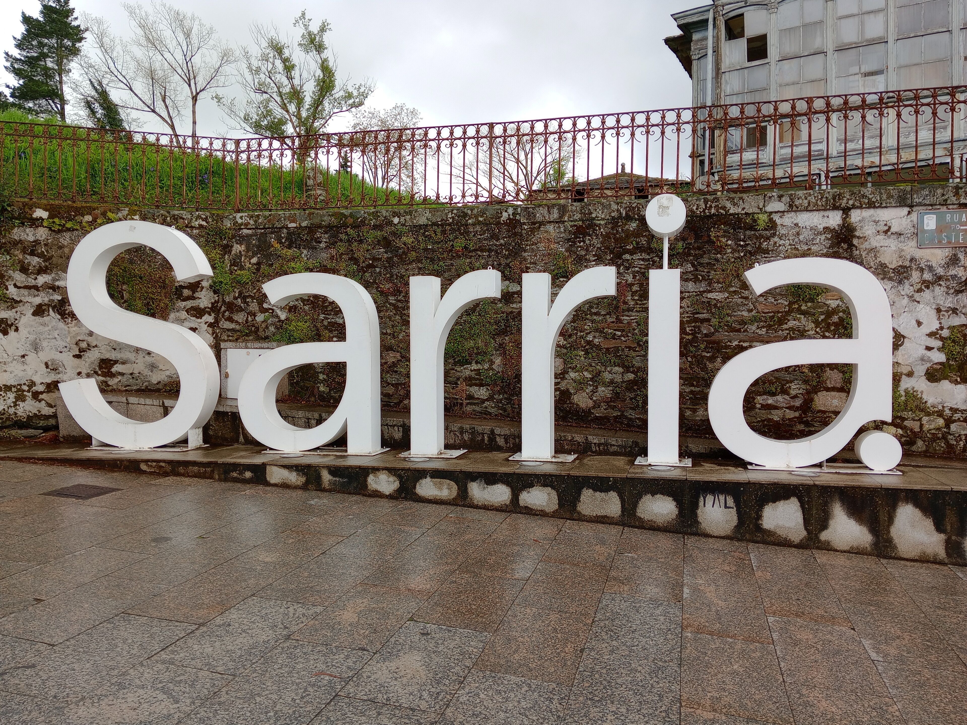 A large white sign with the word "Sarria" in capital letters.
