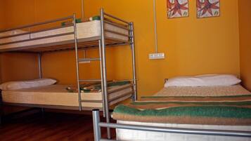 Dormitorio con literas, suelo de madera y pared amarilla.