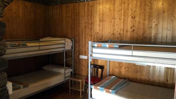 Habitación con literas, paredes de madera y una pared de acento de piedra.