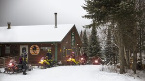 A snow-covered building with a sign reading "CAFE" and "RAVEN ROCK GRILL". - Skyport Lodge (Grand Marais)