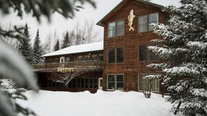 A wooden lodge with a balcony and a fish hanging on the wall. - Skyport Lodge (Grand Marais)