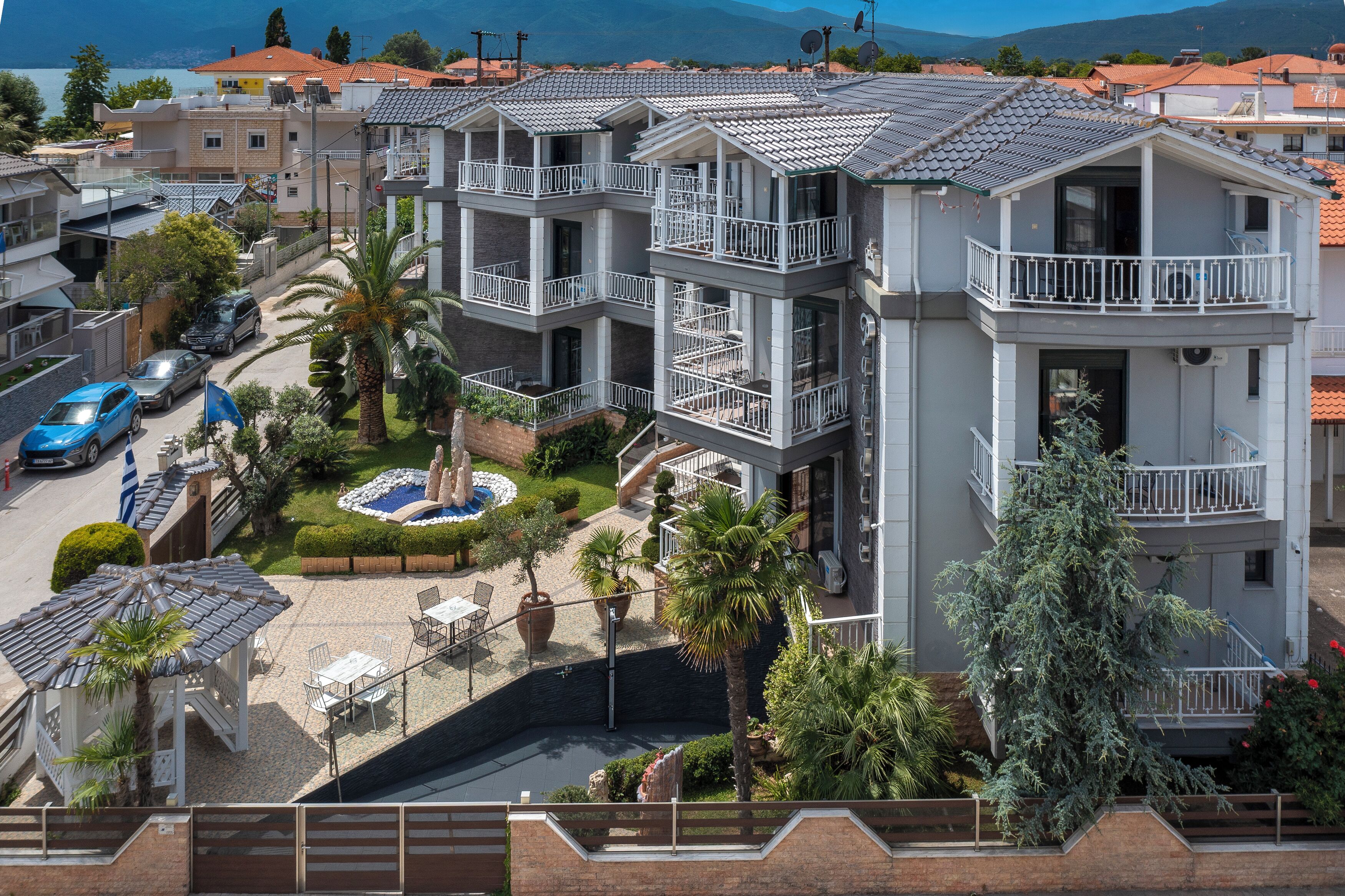A multi-story residential building with balconies, a swimming pool, and a garden area.
