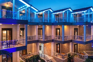 Un hotel de varios pisos con balcones y zonas de estar al aire libre.