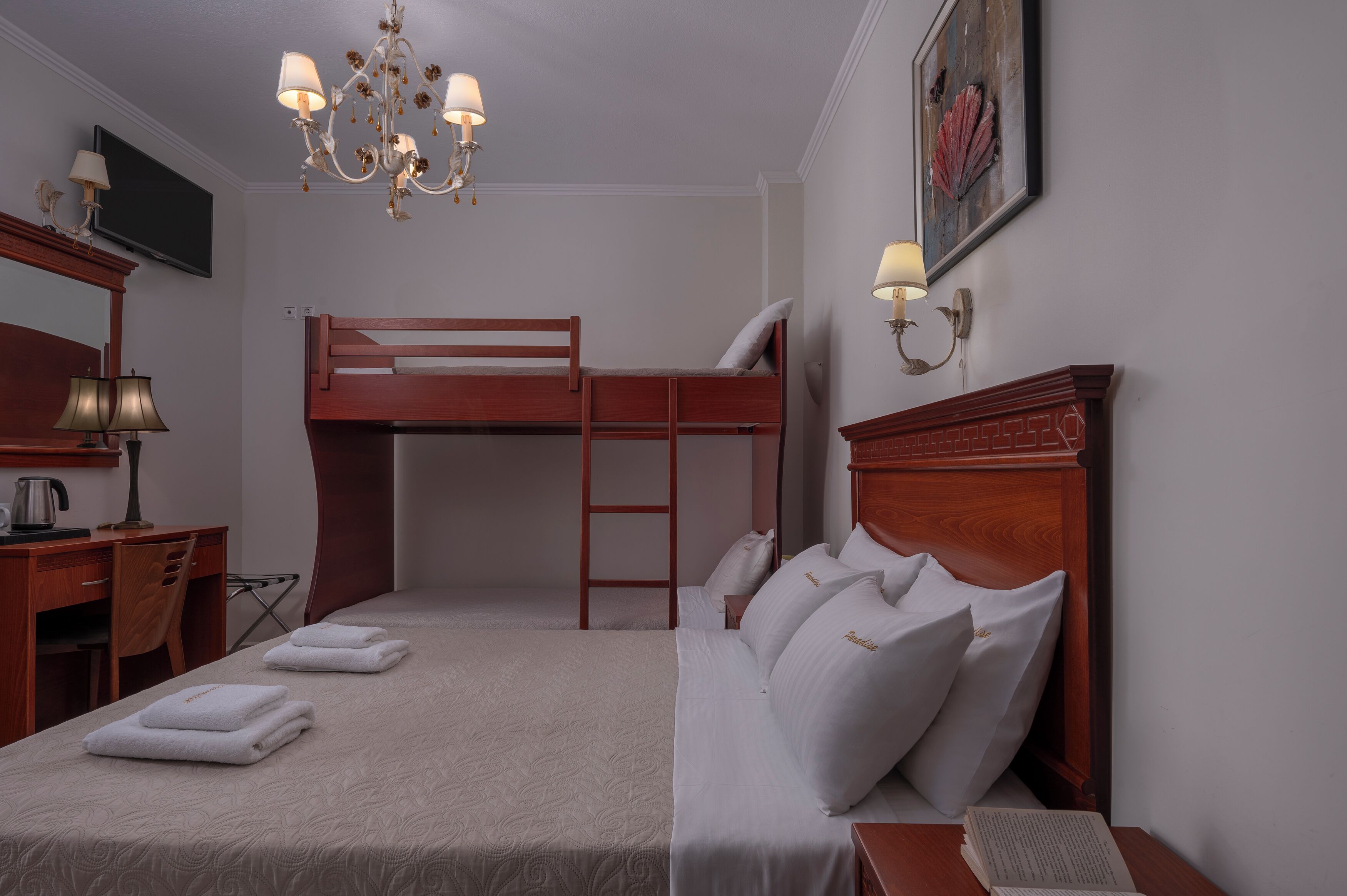 Habitación con literas, un escritorio, una silla y un candelabro.