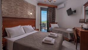 A hotel room with two beds, a desk, a chair, a TV, and a view of the outdoors. - Paradise (Volvi)