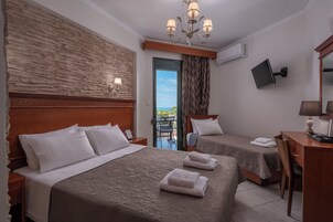 Habitación de hotel con dos camas, un escritorio, una silla, un televisor y vistas al exterior.