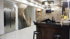 A modern kitchen with a central island, stainless steel appliances, a chandelier, and a decorative wall. - Paradise (Volvi)