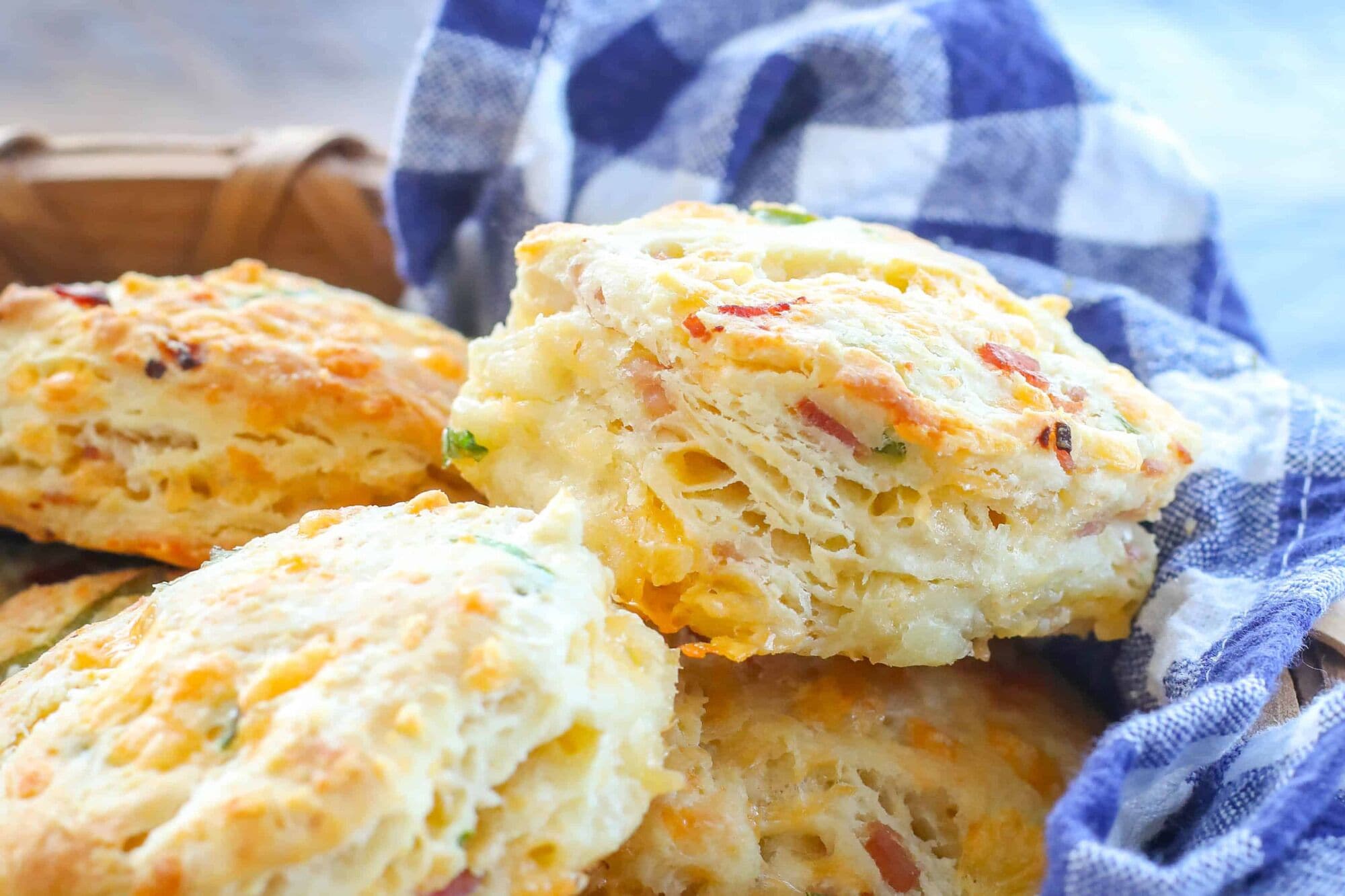 Uma pilha de biscoitos recém-assados, com queijo e ervas à vista.